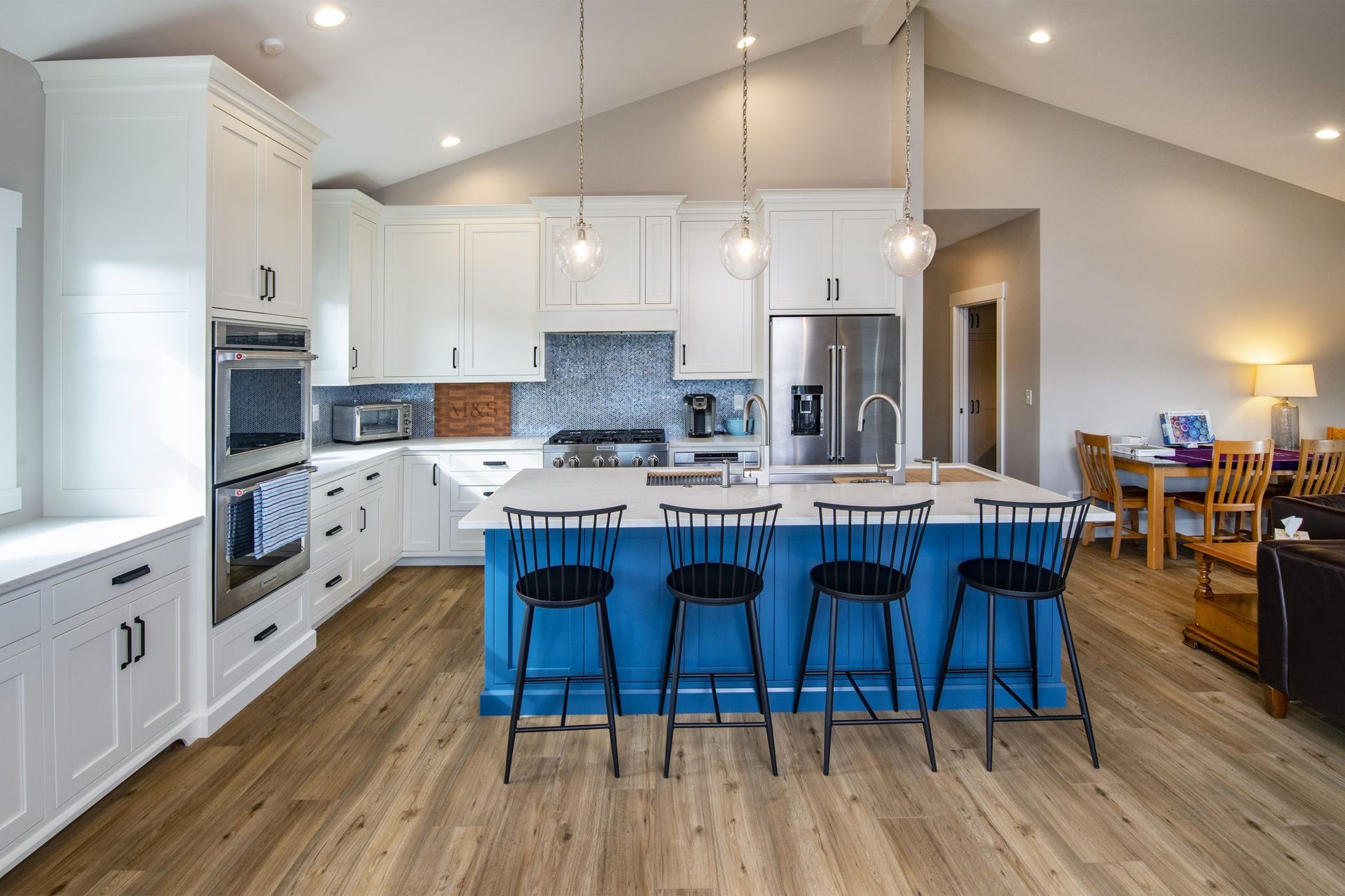 A kitchen with white cabinets and a blue island.