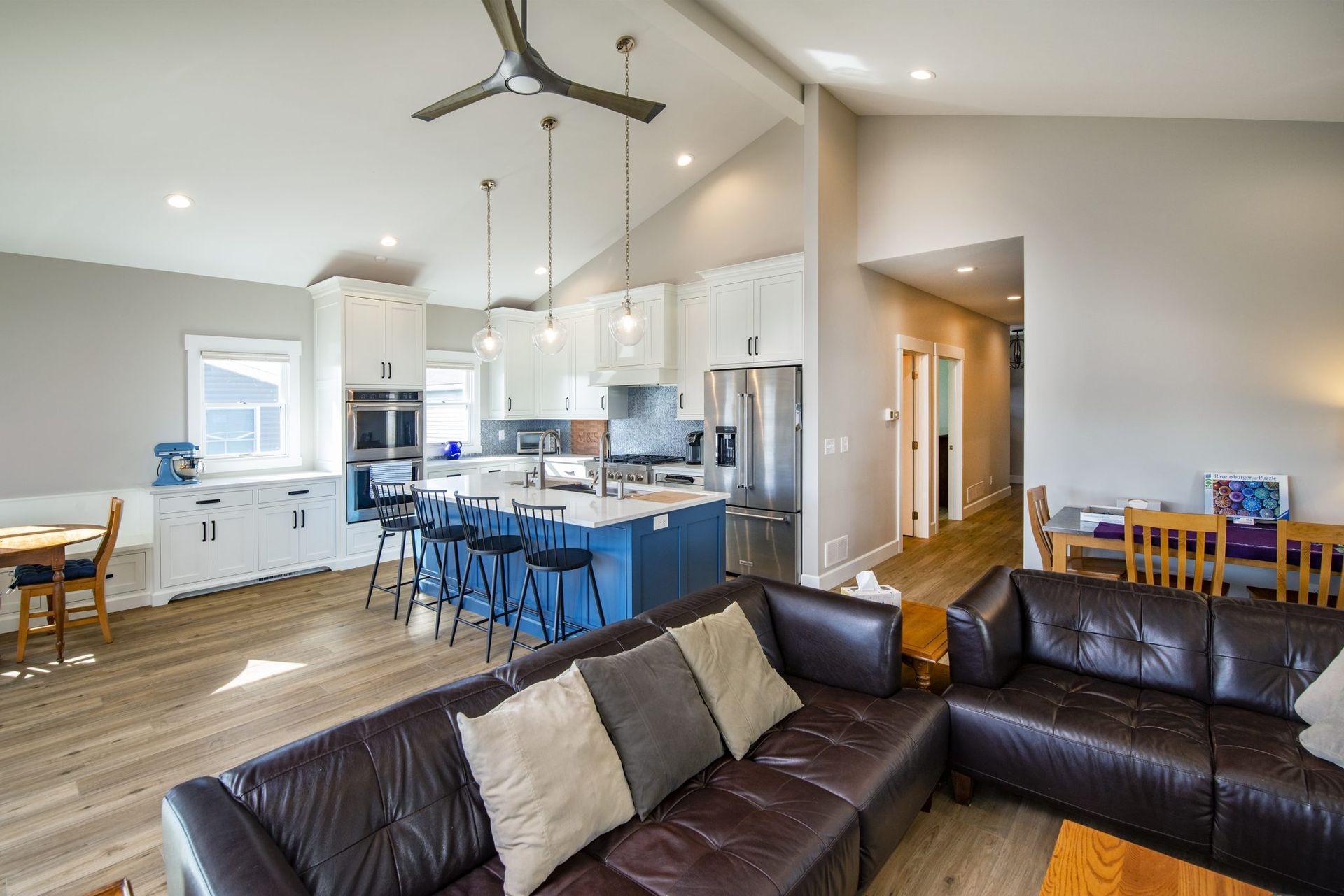 A living room with a couch and a kitchen in the background.