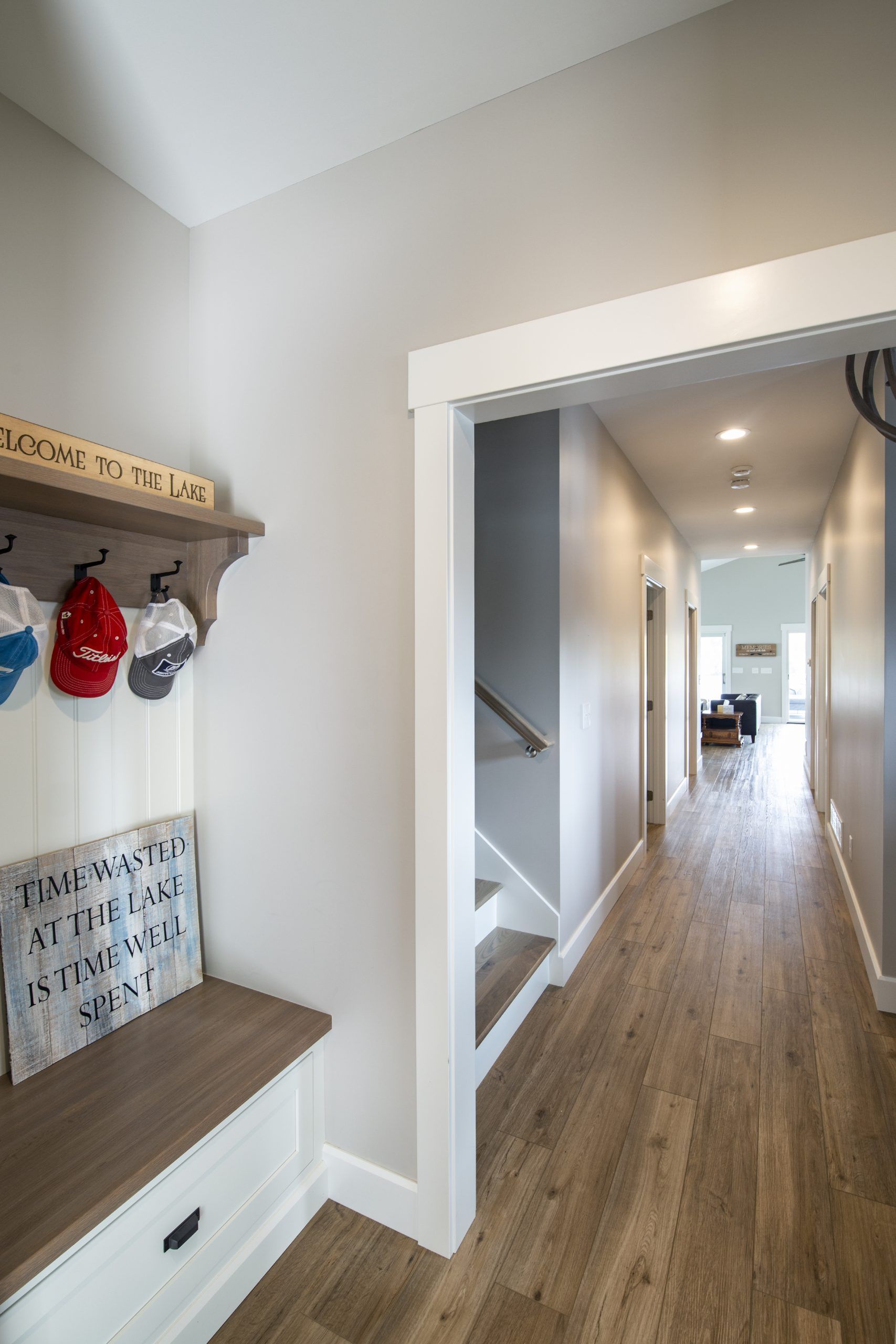 A hallway with a bench and stairs leading to the second floor.