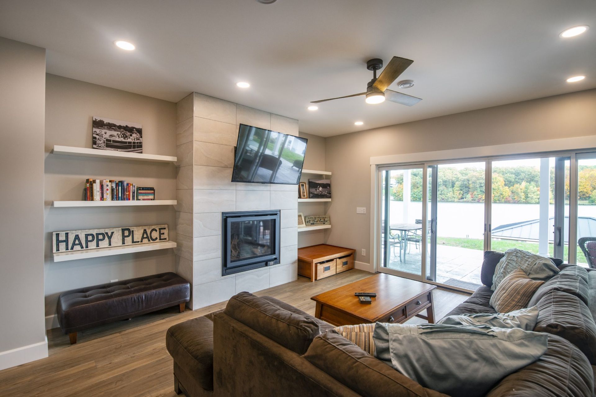 A living room with a couch, fireplace, television, and sliding glass doors.