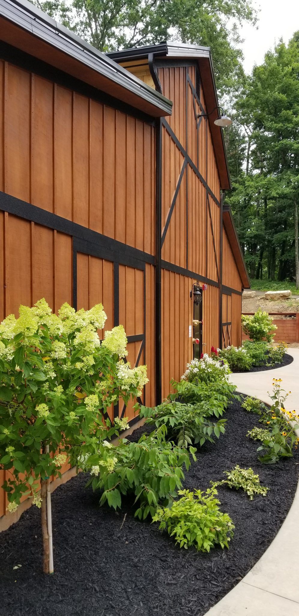 A large wooden barn with a walkway leading to it.