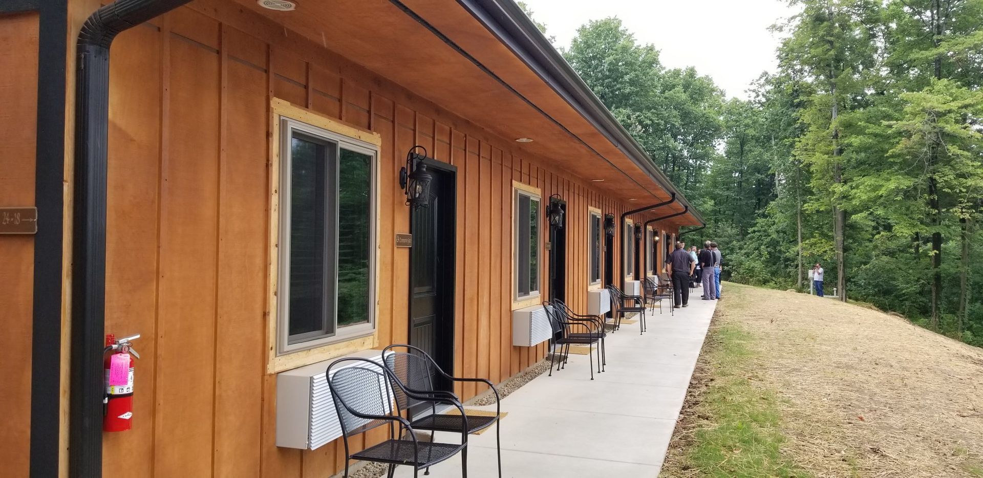 A wooden building with a fire extinguisher on the side of it.