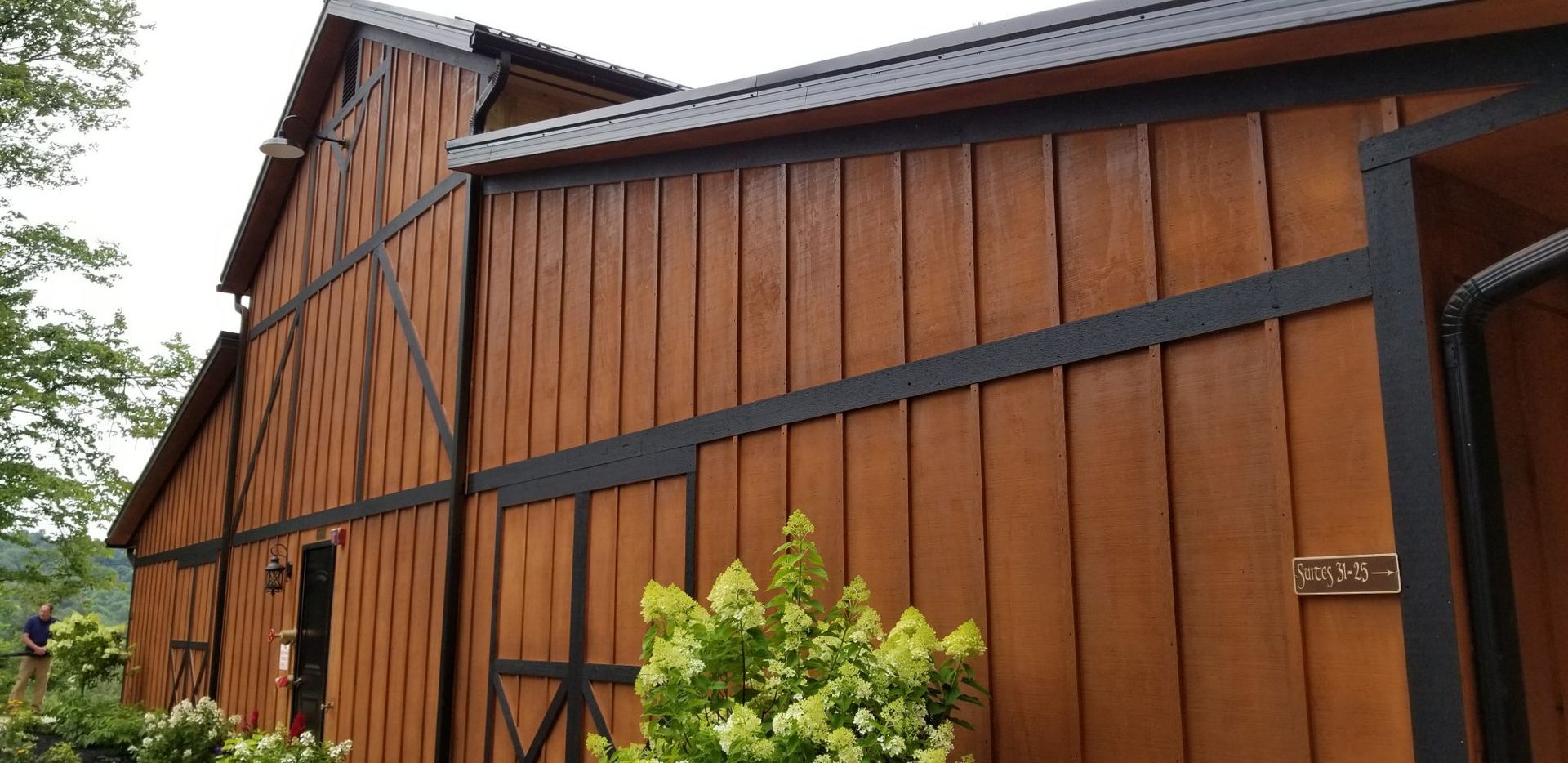 A large wooden barn with a black roof.