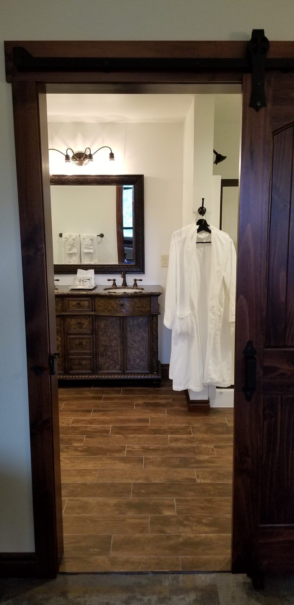 A bathroom with a sliding barn door leading to it.