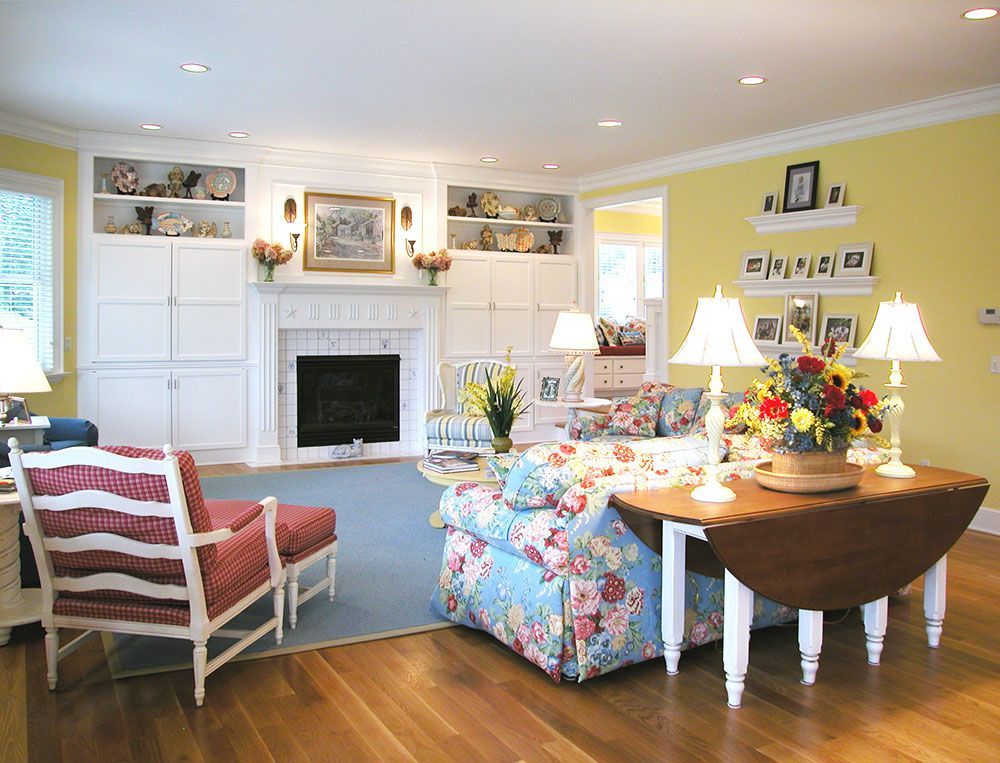 A living room with yellow walls and a fireplace.