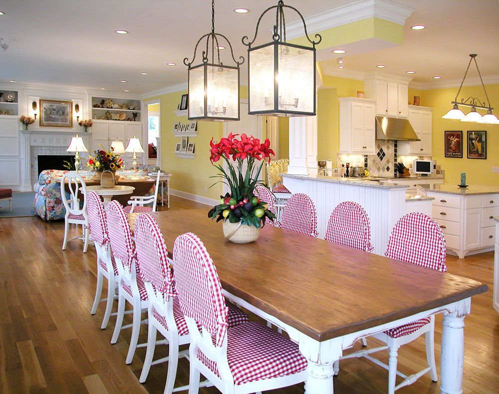 A dining room table with a vase of flowers on it.