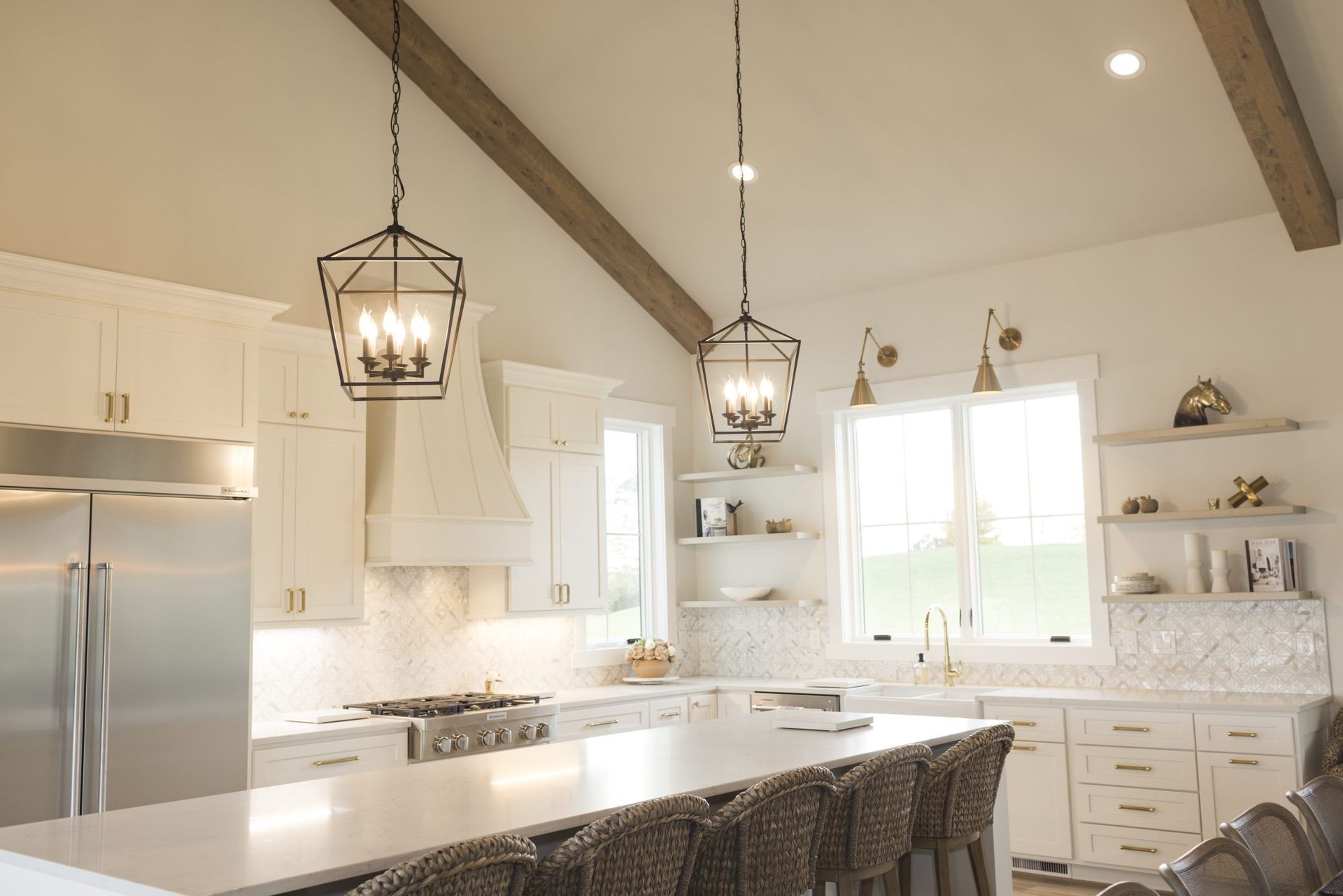 A kitchen with white cabinets and stainless steel appliances and a vaulted ceiling.