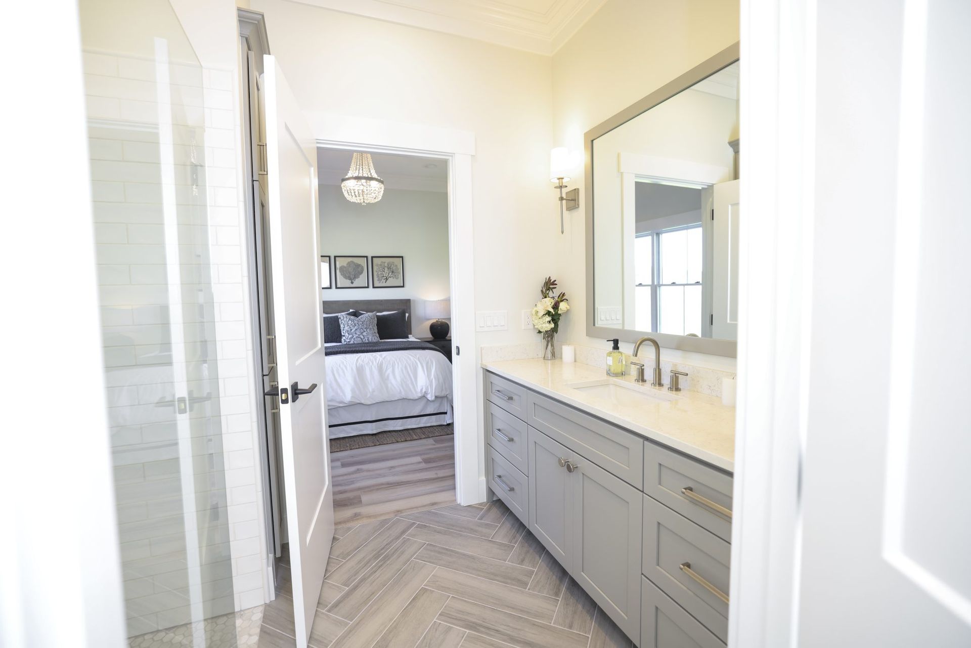 A modern bathroom with two sinks, a mirror, and a walk in shower.