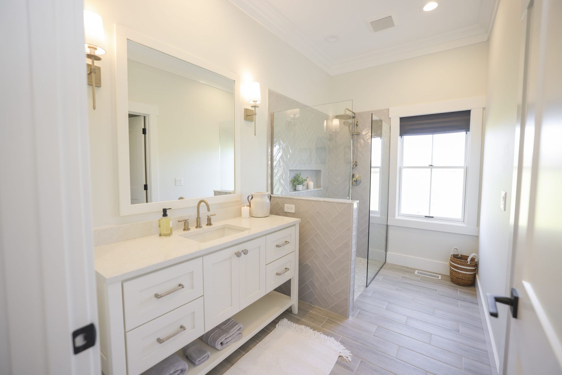 A bathroom with a sink, mirror, and walk in shower.