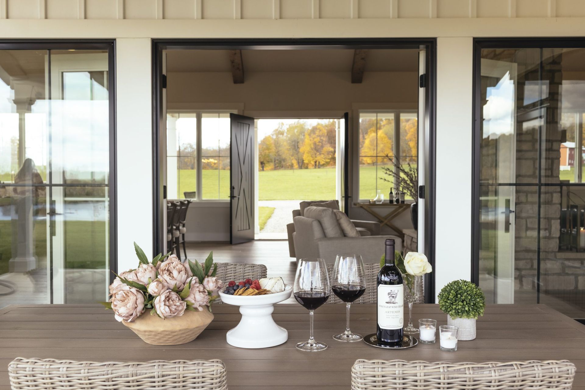 A table with a bottle of wine and two glasses on it.