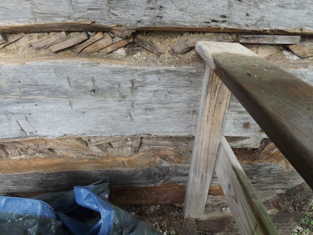 A close up of a piece of wood with a blue tarp in the background.