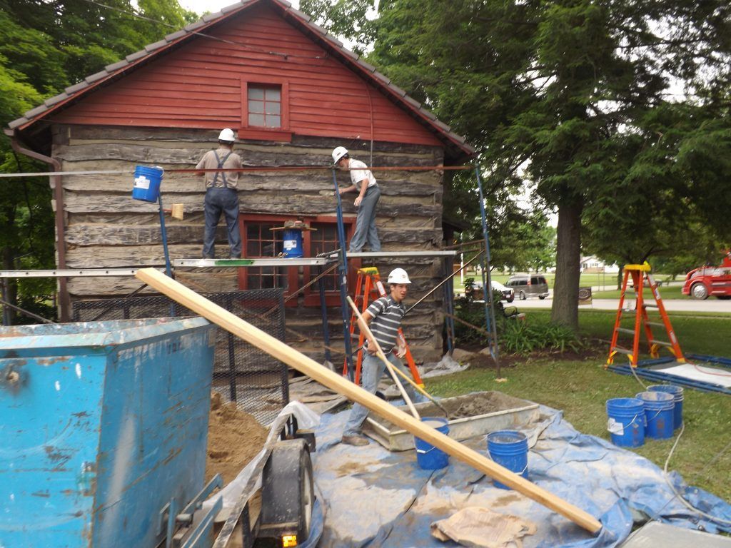 A group of men are painting the side of a building