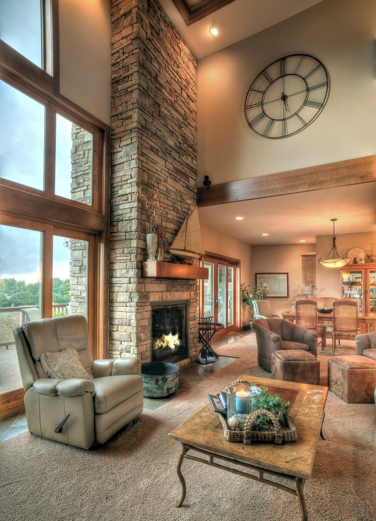 A living room with a fireplace and a clock on the wall.