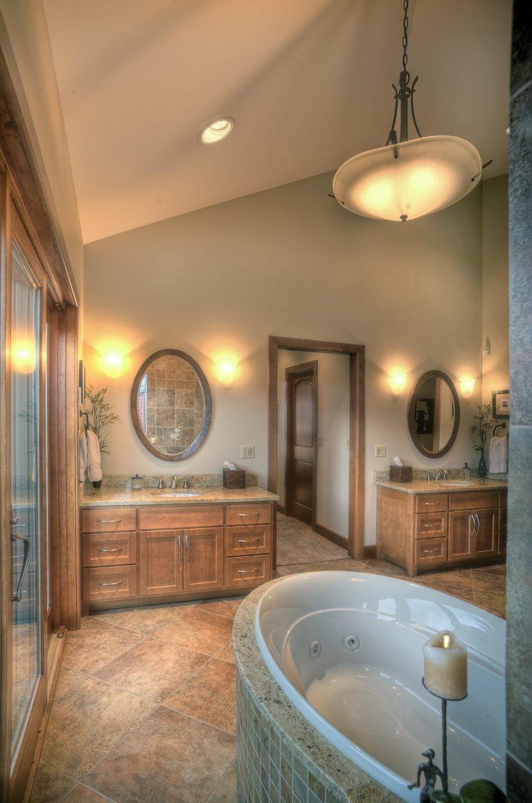 A bathroom with two sinks and a bathtub with a candle in it.