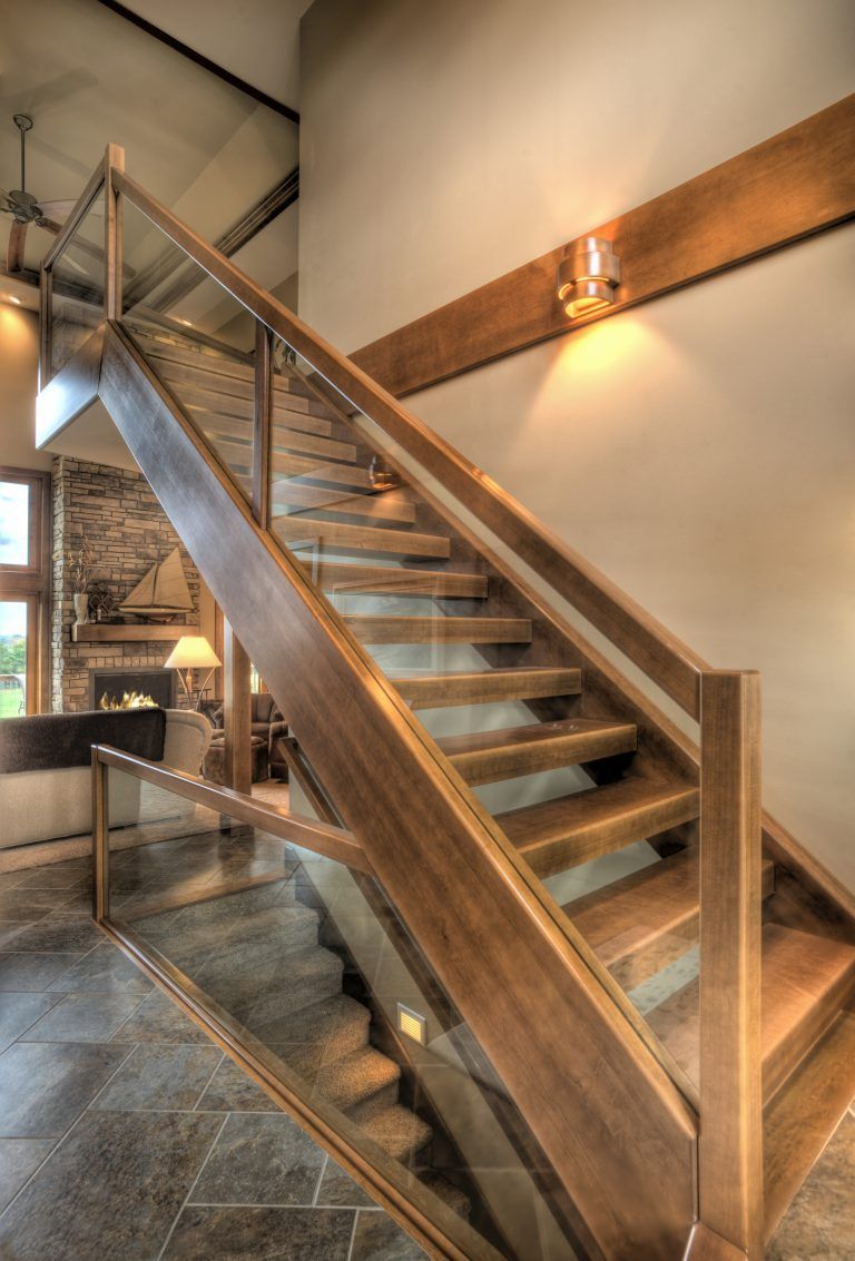 A wooden staircase with a glass railing in a house