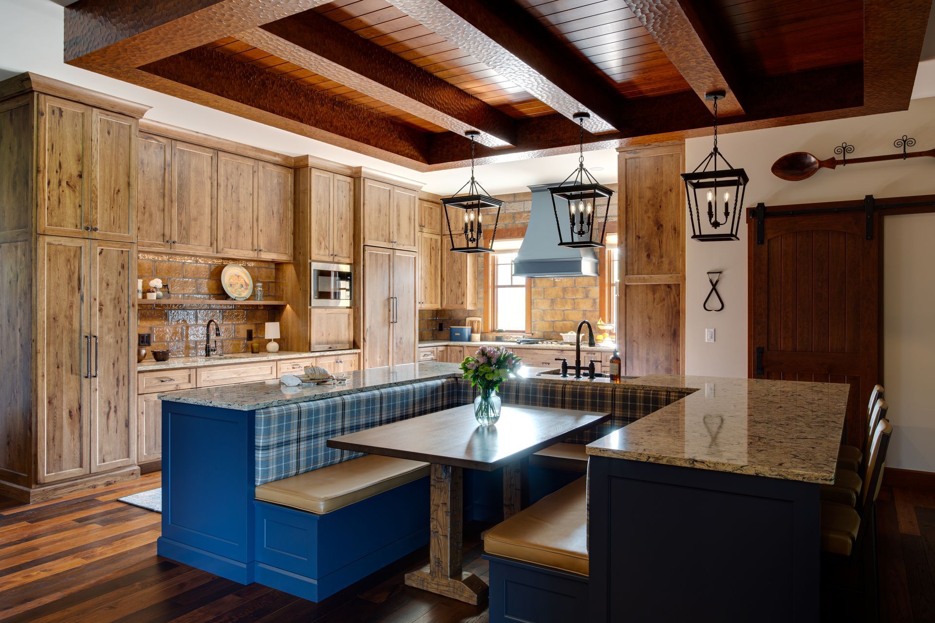 A kitchen with a table and benches in the middle.