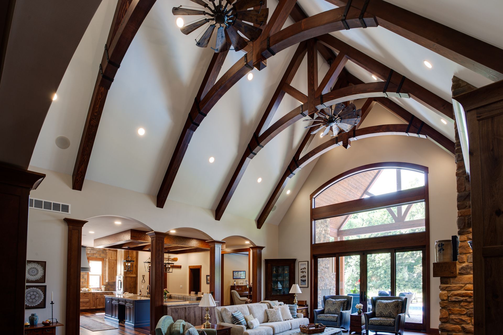 A living room with a vaulted ceiling and custom ceiling fans.