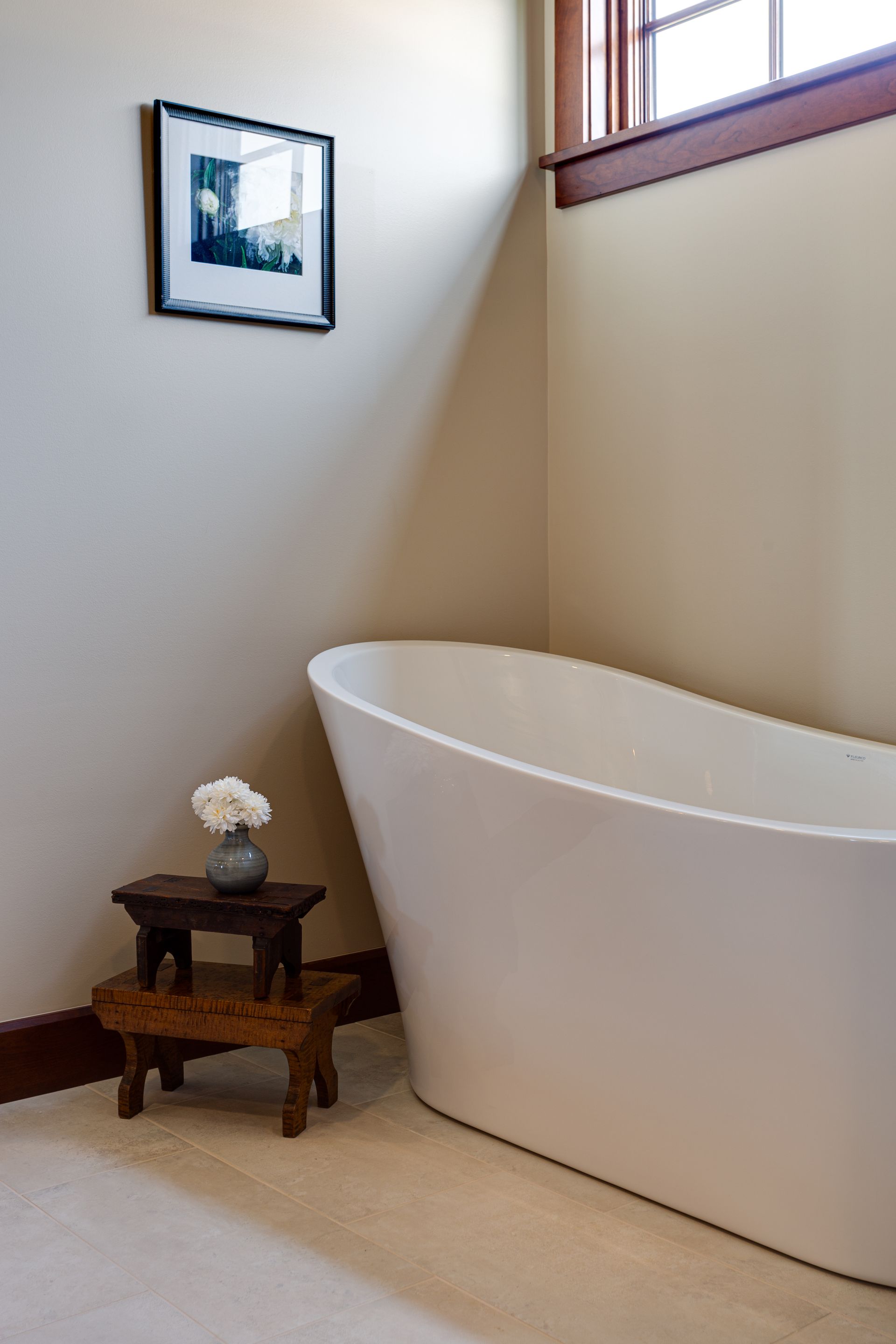 A bathroom with a bathtub and a picture on the wall.