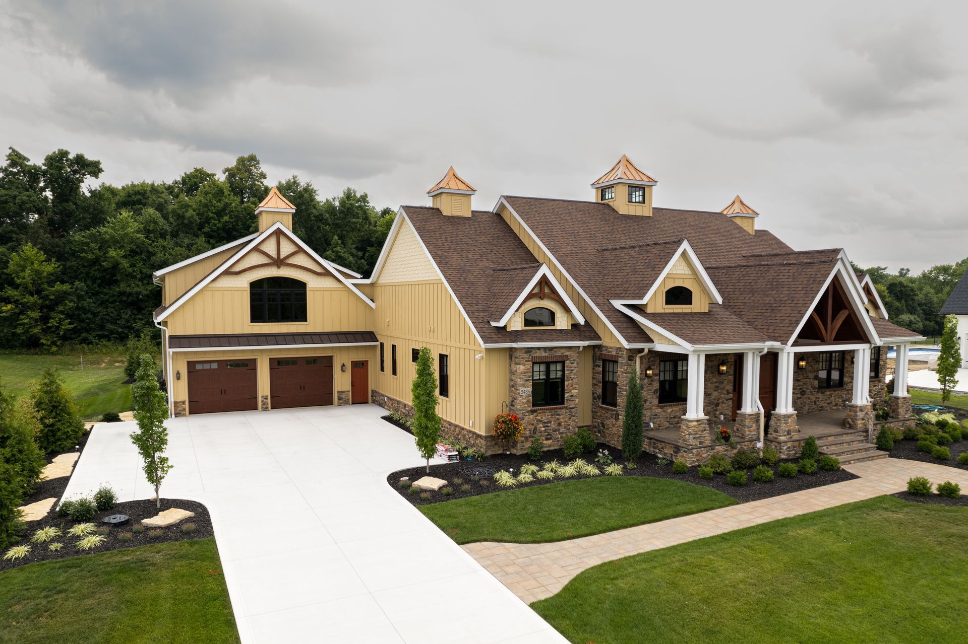 An aerial view of a large house with a driveway leading to it.