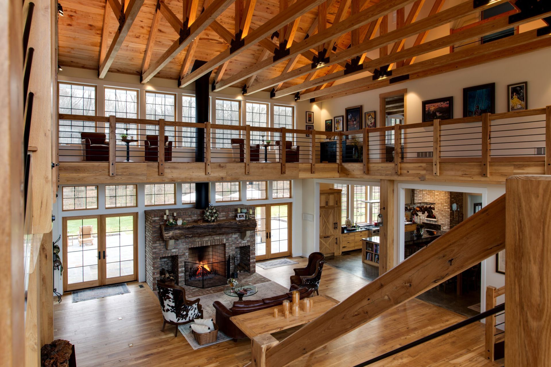 A balcony overlooking a large living room with a fireplace and stairs.