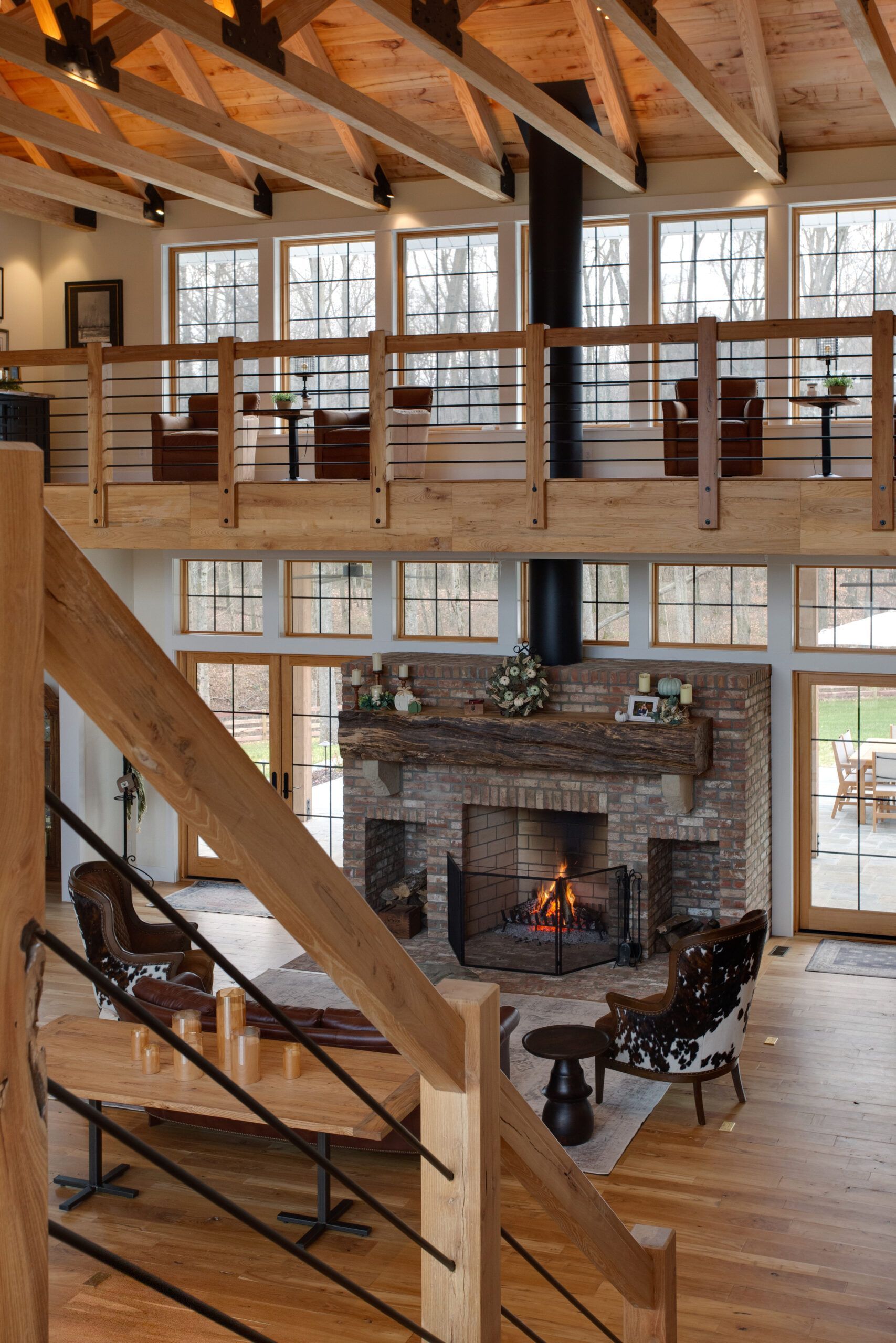 A living room with a fireplace and many windows.