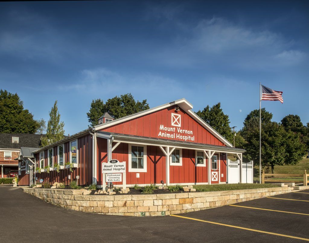 A large red barn with an american flag in front of it.