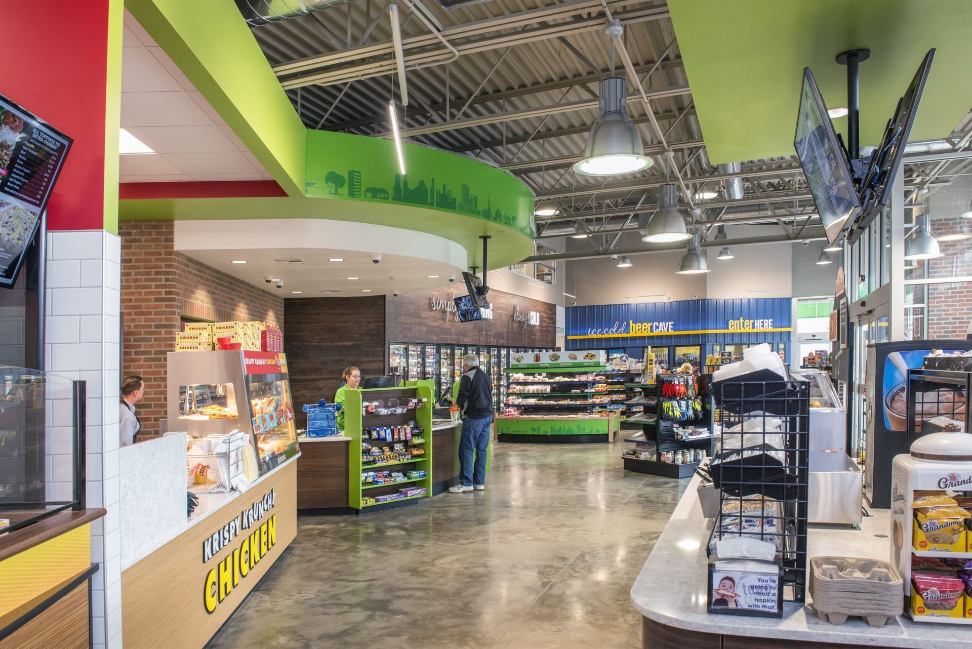 The inside of a grocery store with people standing in the aisles.