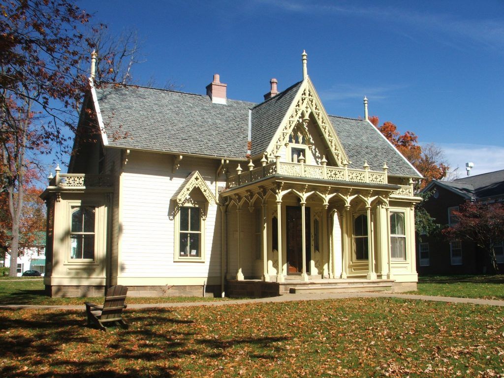 A white house with a gray roof and arched windows.