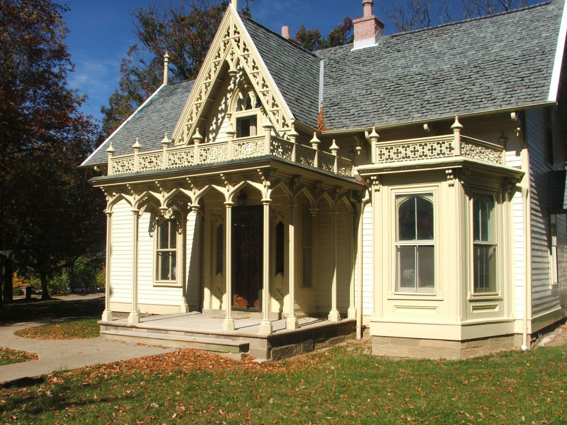 A white house with a gray roof and a porch.