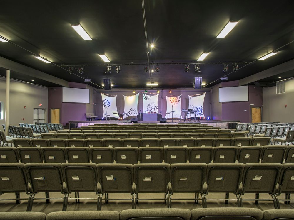 A large auditorium with rows of seats and a stage in the background.