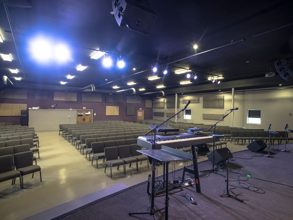 A large auditorium with rows of chairs and a stage.