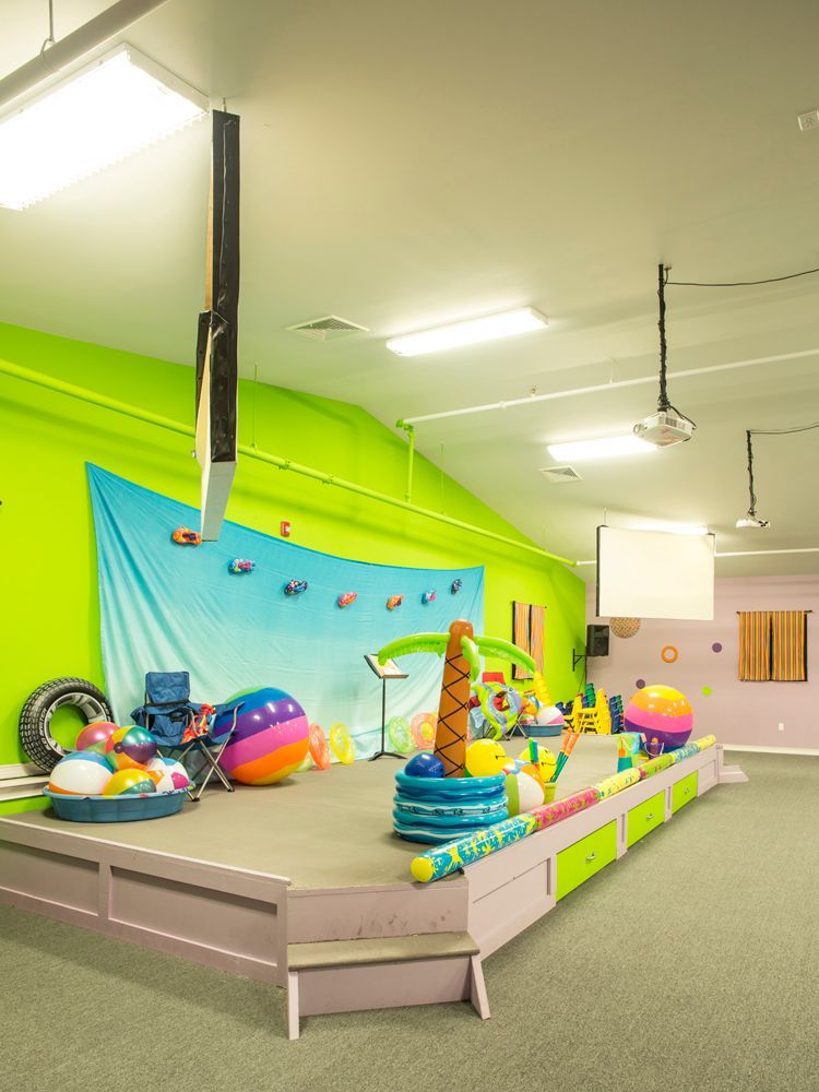 A room with a stage and a bunch of beach balls on it.