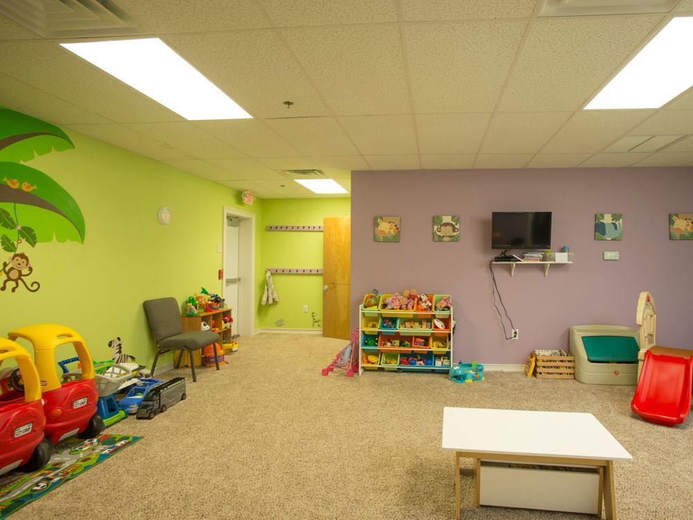 A room with a lot of toys and a television on the wall.