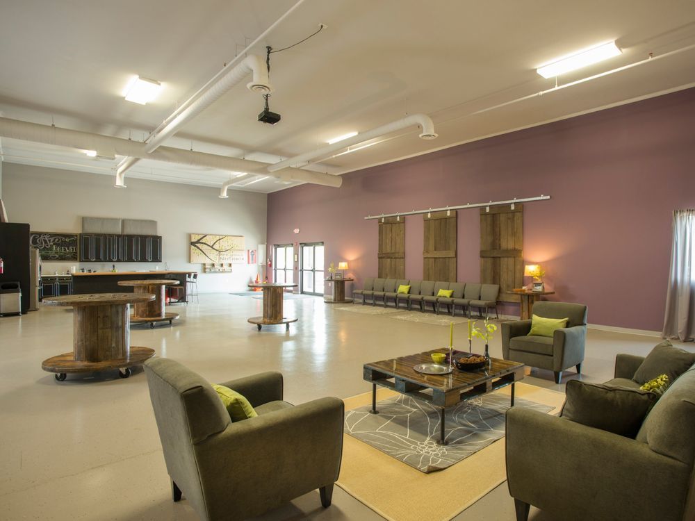A living room with purple walls, chairs and a coffee table.