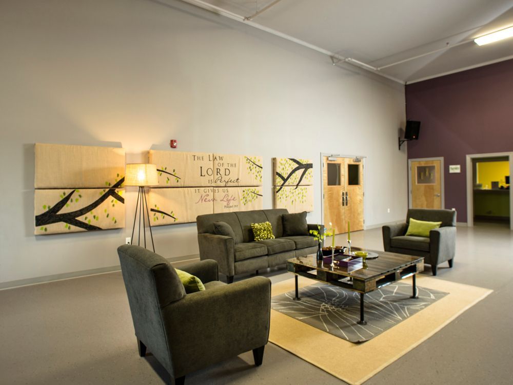 A living room with a couch, chairs, and a coffee table.