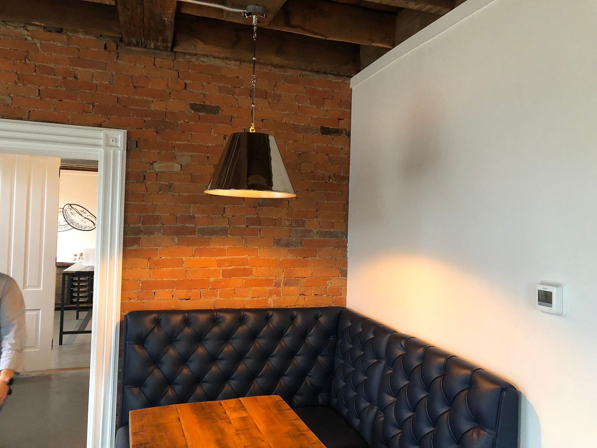 A room with a brick wall and a wooden table.