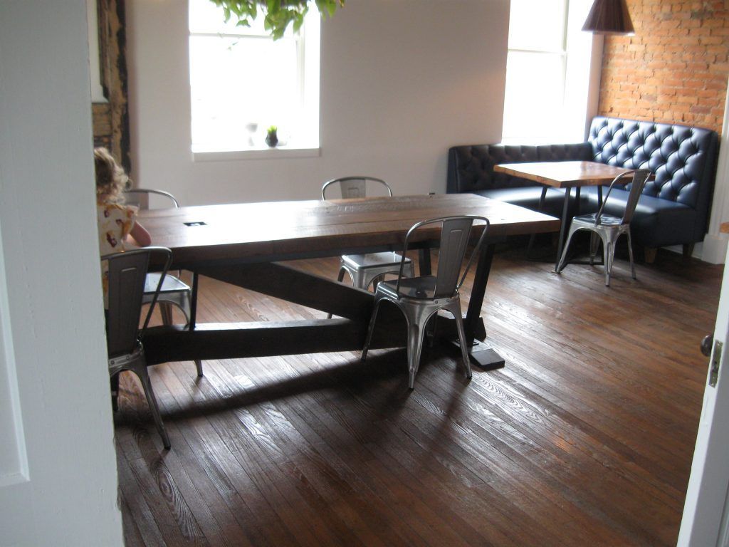 A room with wooden floors and tables and chairs.