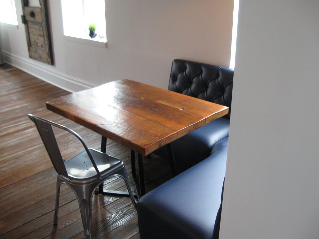 A wooden table with two chairs in a room.