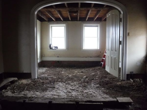 A room with a ladder in it and a few windows.