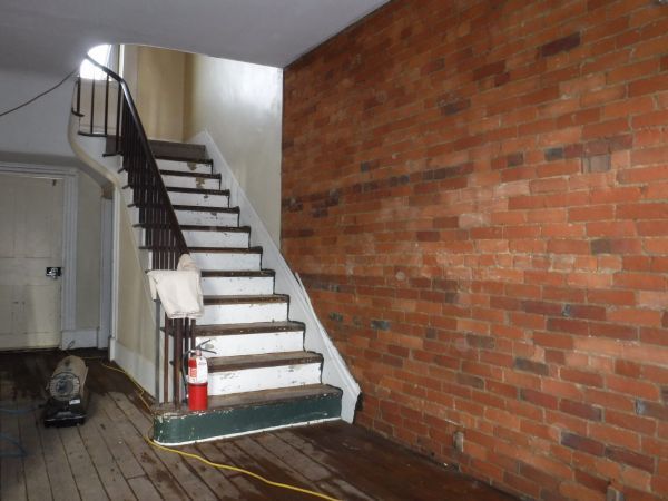 A staircase in a room with a brick wall.