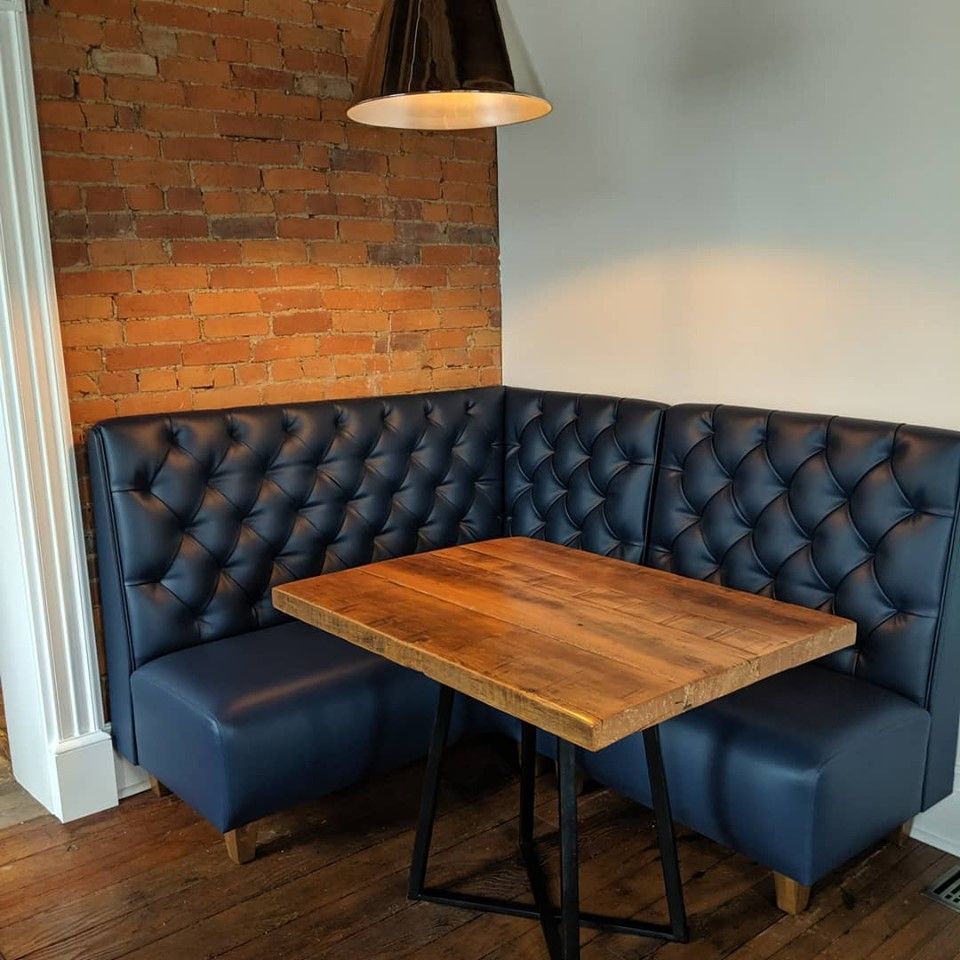 A corner booth with a wooden table.