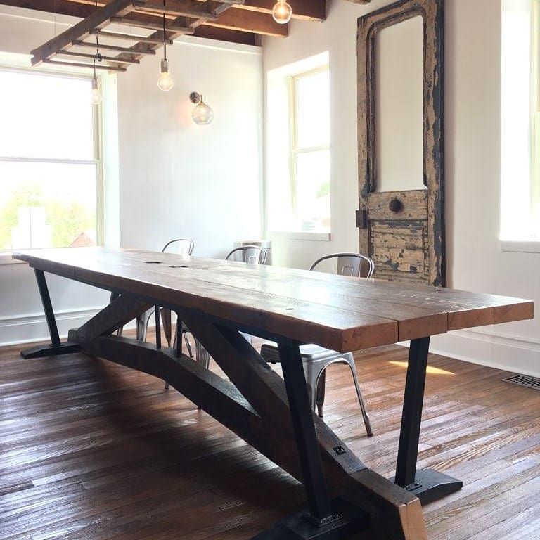 A long wooden table is sitting in a room with chairs.