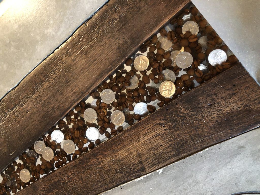 A close up of a wooden table with coins on it.