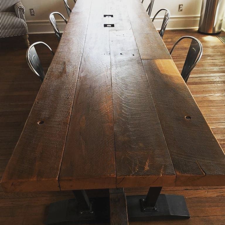 A long wooden table with metal chairs in a room.