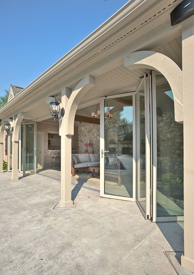 A covered patio with a couch and sliding glass doors.