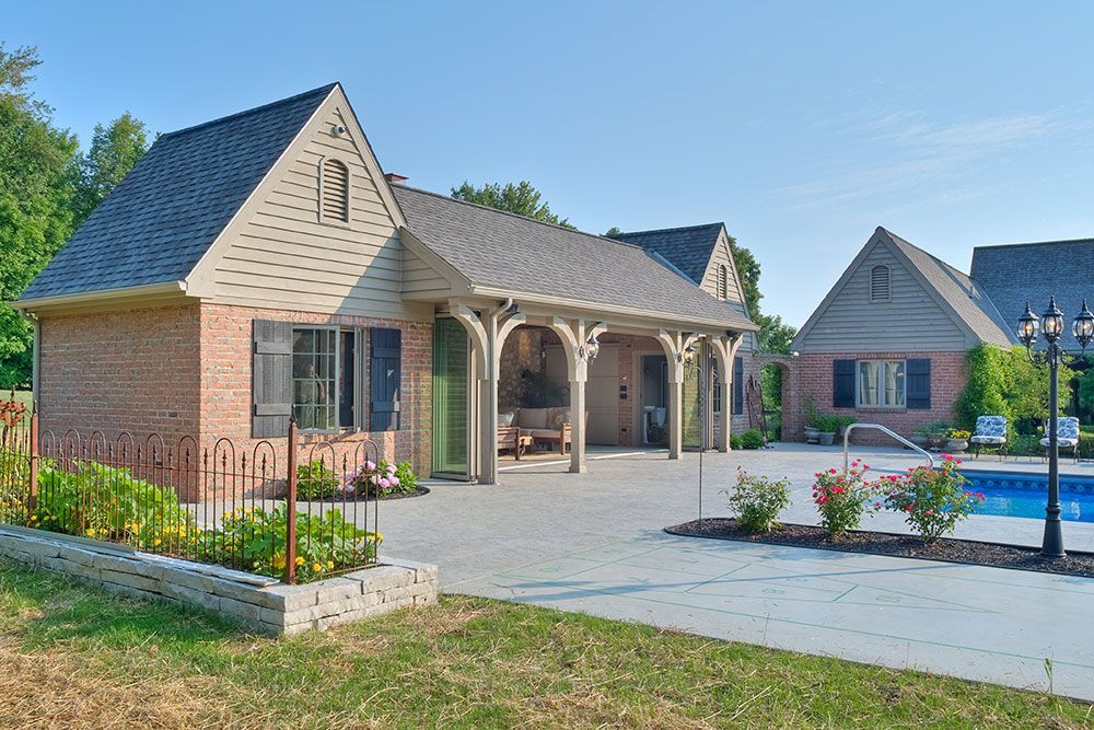 A large brick house with a pool in front of it.