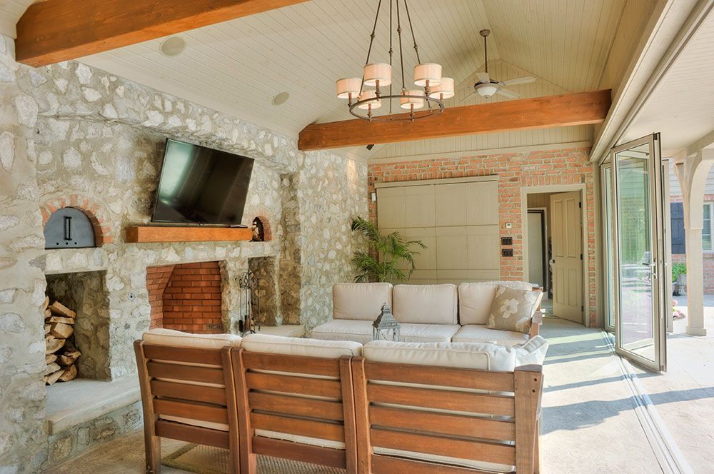 A living room with a couch, chairs, a fireplace and a television.