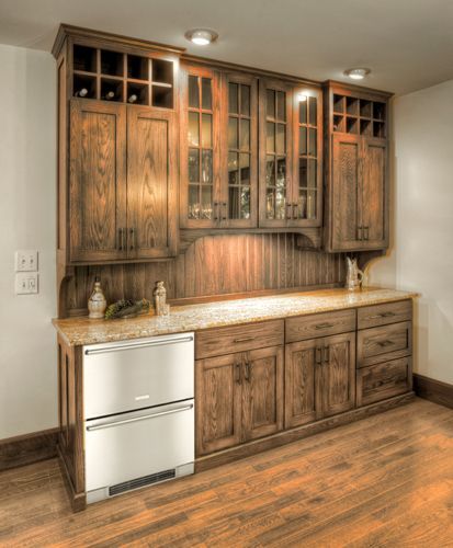 A kitchen with wooden cabinets and a stainless steel refrigerator.