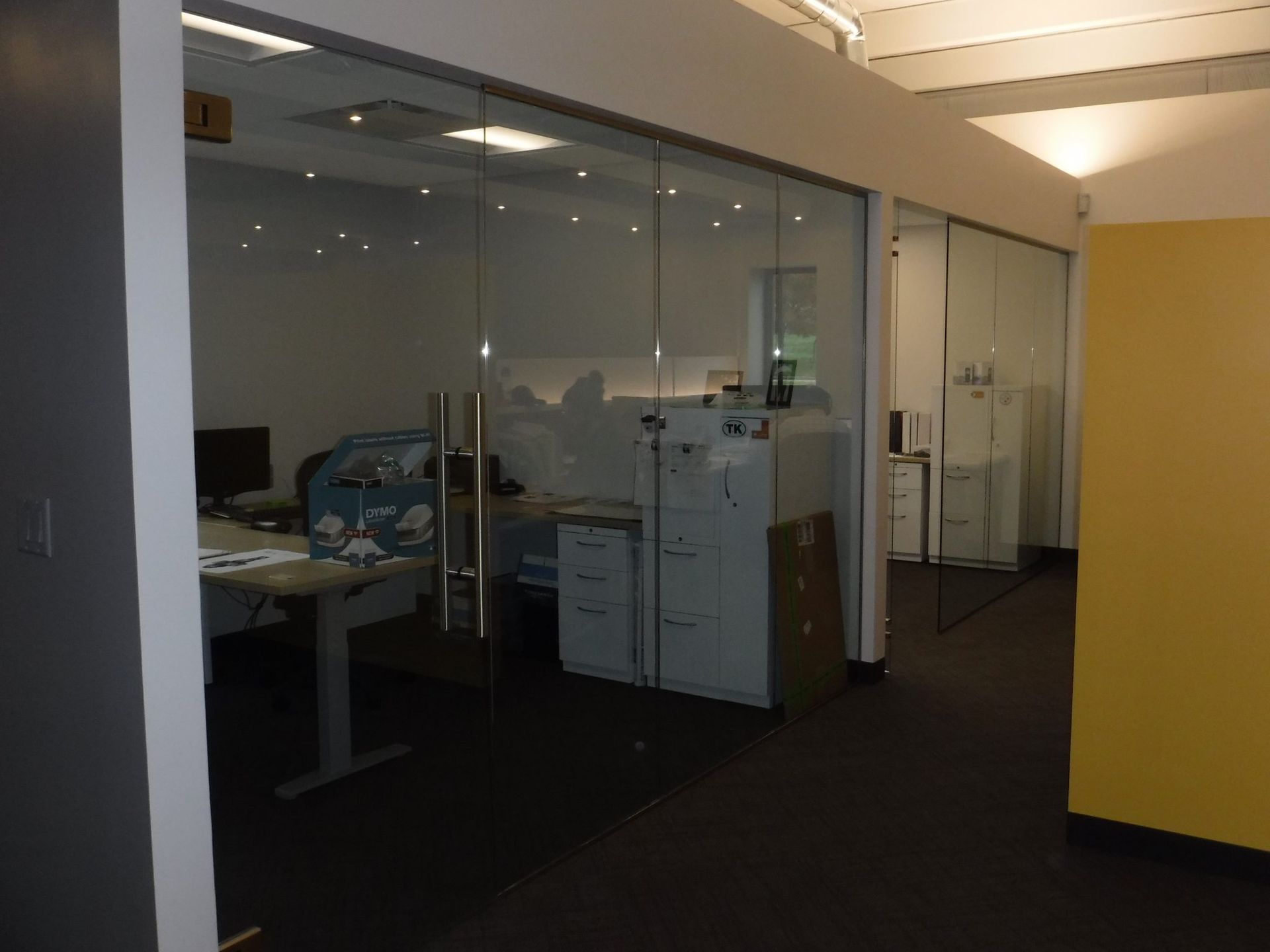 A room with a desk and a fan in it.