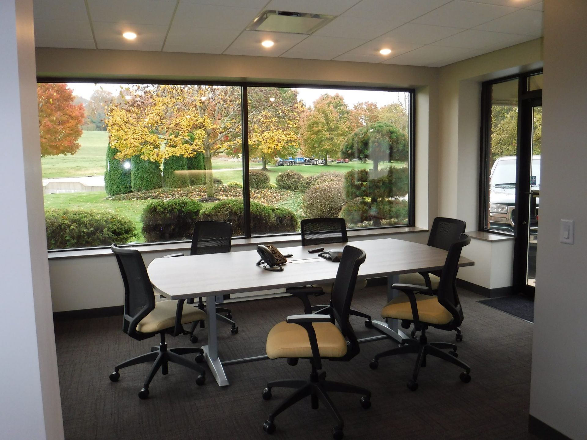 A conference room with a table and chairs and a large window.